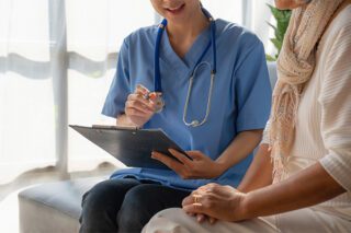 Health professional with clipboard talking to a patient about their mesothelioma treatment